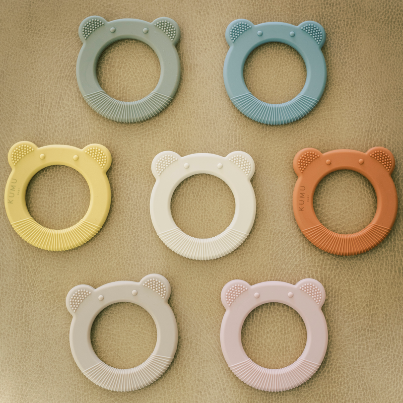 Photo of seven bear shaped baby teethers in 7 different colors.